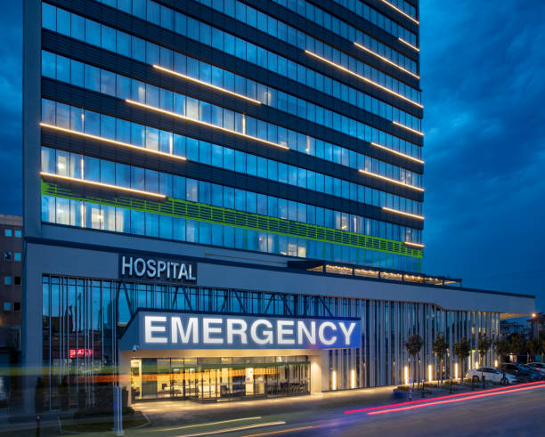 Emergency room entrance at modern hospital building in front of night sky.