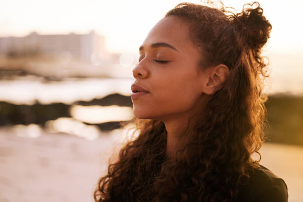 A woman meditates on the beach.