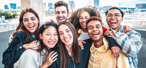 A group of youths smiling and embracing each other.